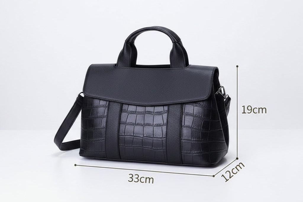 Black handbag with measurements on a light gray surface